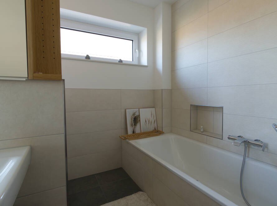 Helles Badezimmer mit Badewanne und Chrom-Aufputzarmaturen