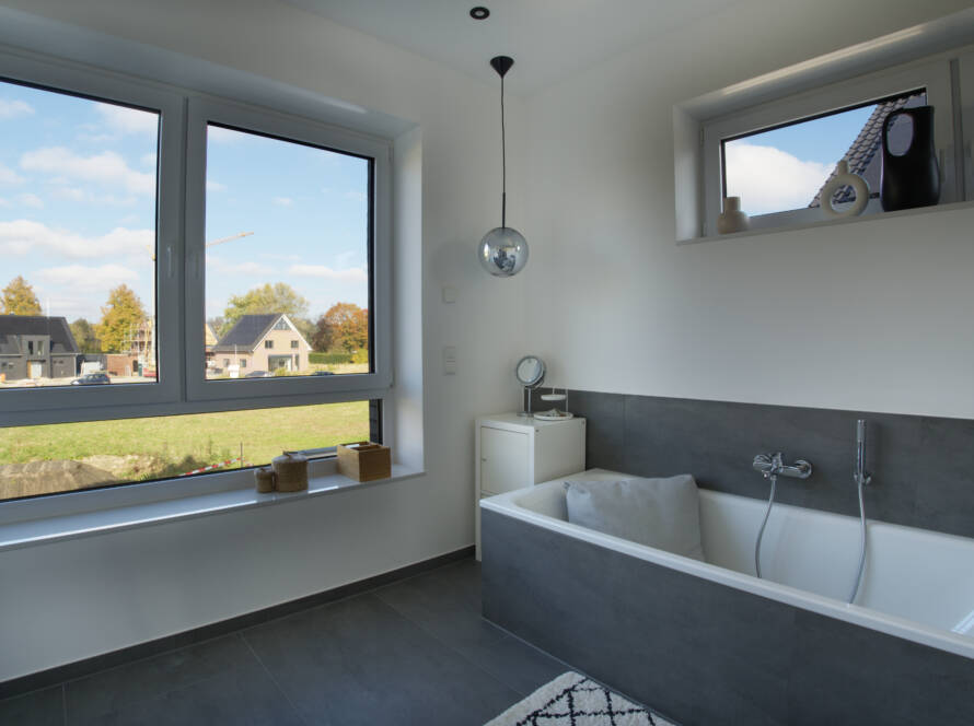 Badezimmer mit großen Fenstern und Badewanne