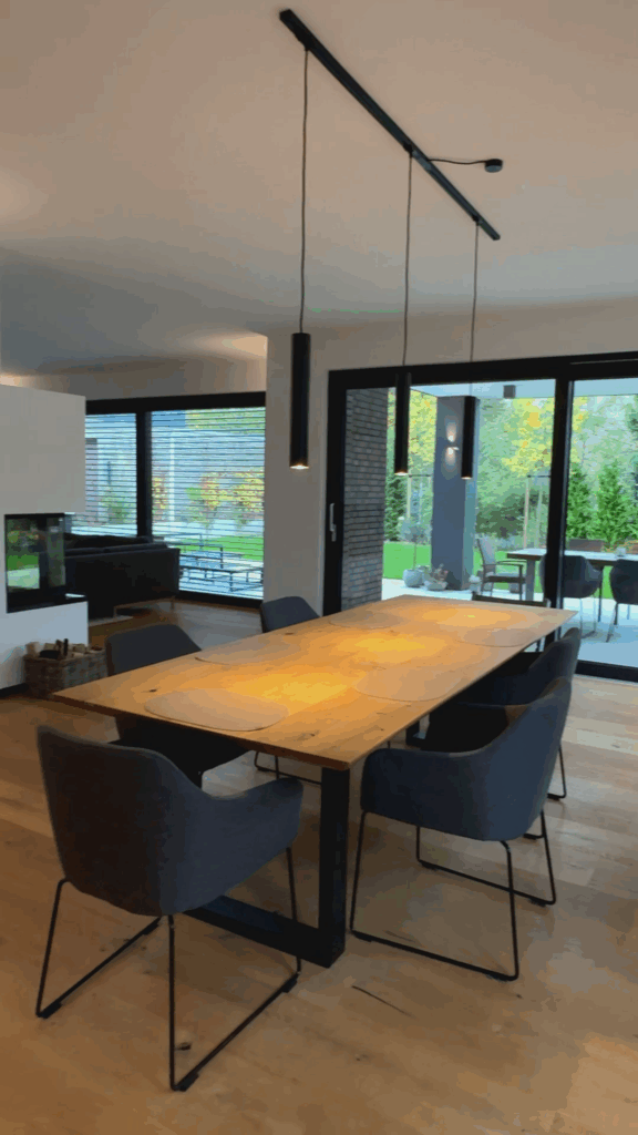 Großer Holz-Esstisch mit modernen, dunklen Stühlen