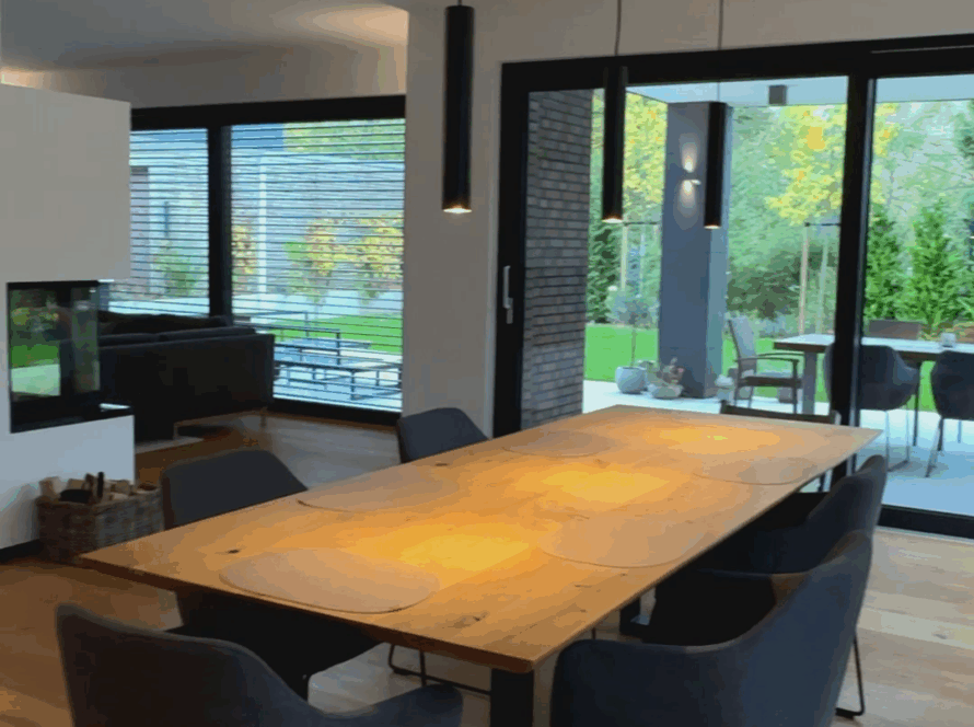 Großer Holz-Esstisch mit modernen, dunklen Stühlen
