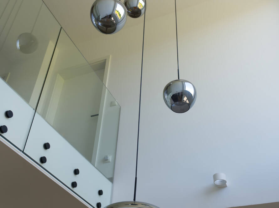 Blick von unten auf offene Galerie mit großer, von der Decke hängender Hängelampe