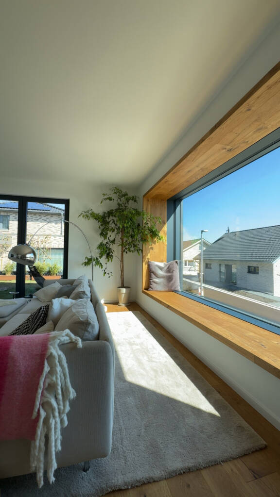 Großes Sitzfenster mit Holz umrahmt