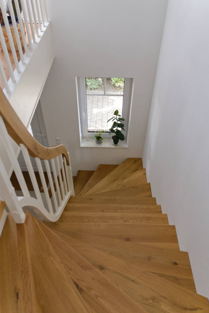 Treppe mit Holzstufen und Holzhandlauf