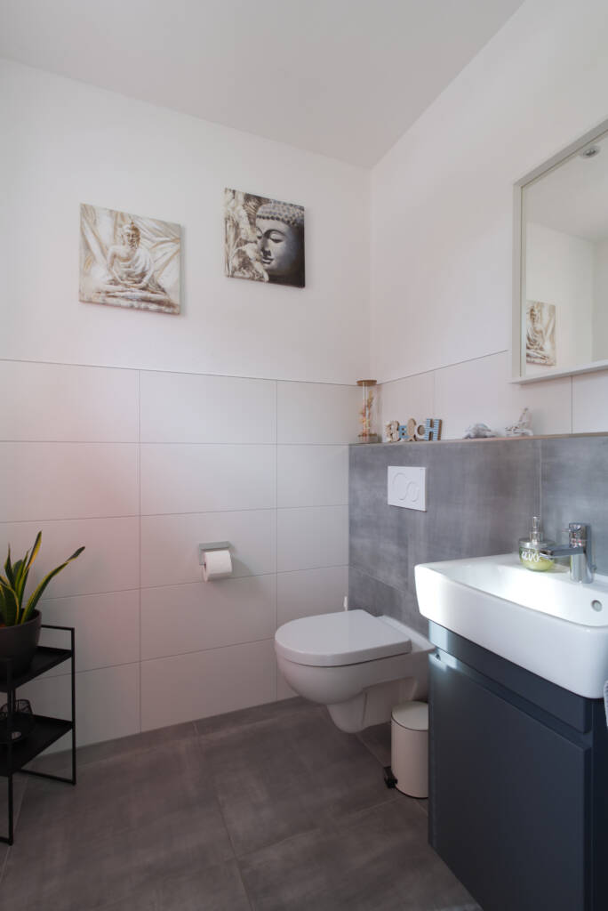 Gästetoilette mit grauen und weißen Fliesen